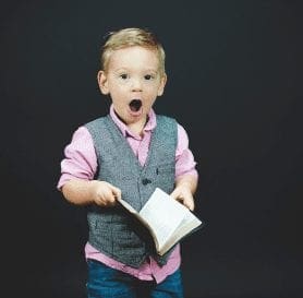 Boy Shocked holding a book of puzzles