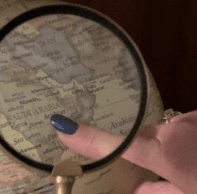 Using a magnifying glass to read a map to solve an escape room puzzle