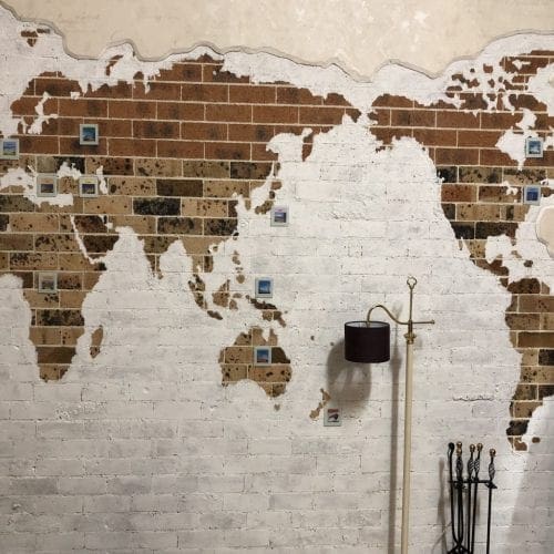 Framed Escape Room showing a map of the world on a brick wall