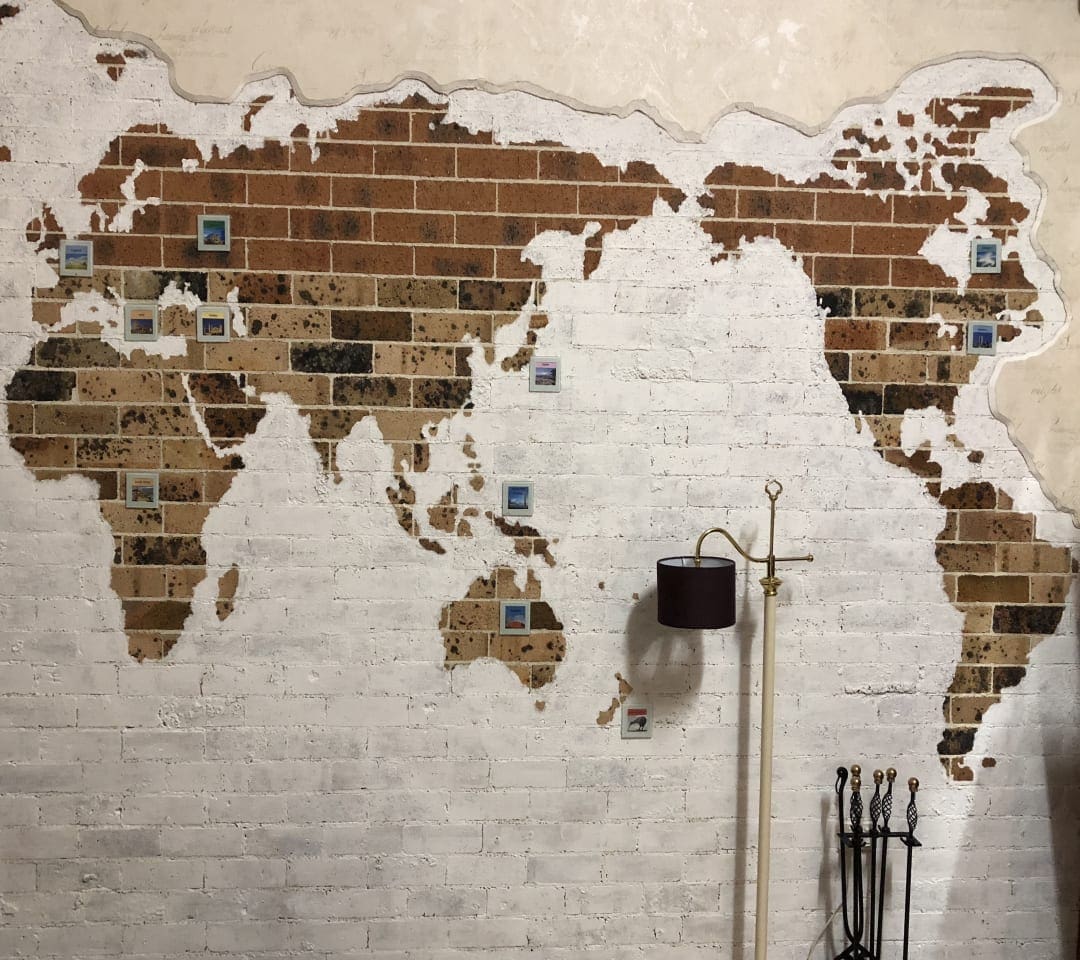 Framed Escape Room showing a map of the world on a brick wall